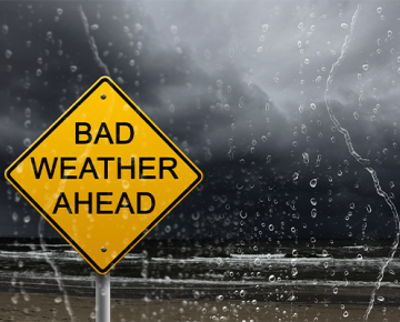 bad weather ahead sign against dark sky and rain