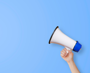 arm holding megaphone against blue background