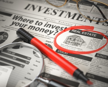 red marker and magnifying glass on newspaper with circled article