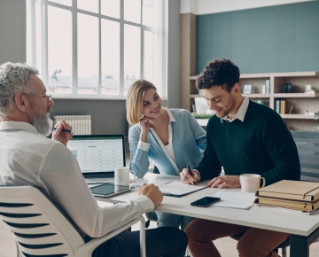 couple signing papers with man in office